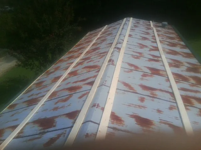 Rusted metal roof panels with new wood purlins before replacement — Storm Damage Roof Repair in Saukville by Roofing Brothers