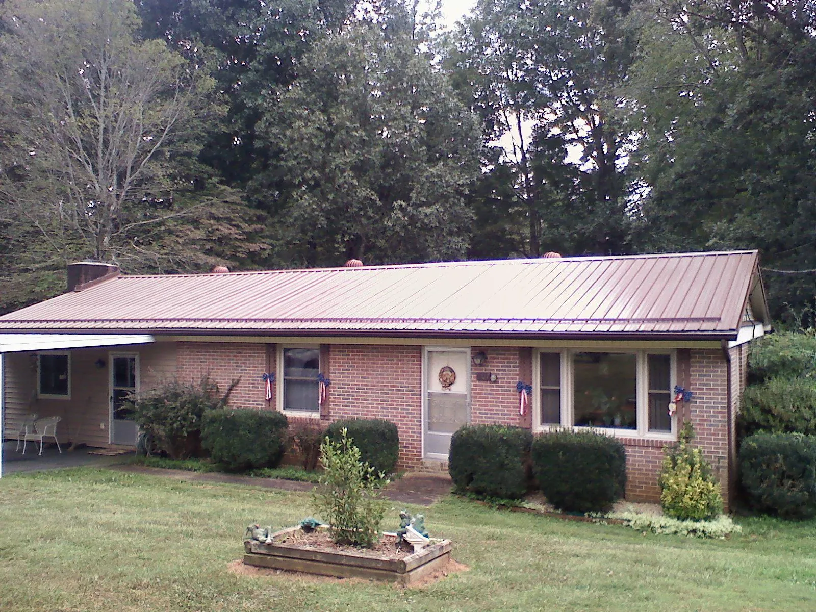 Bronze metal roof on a brick ranch home with a carport in Saukville