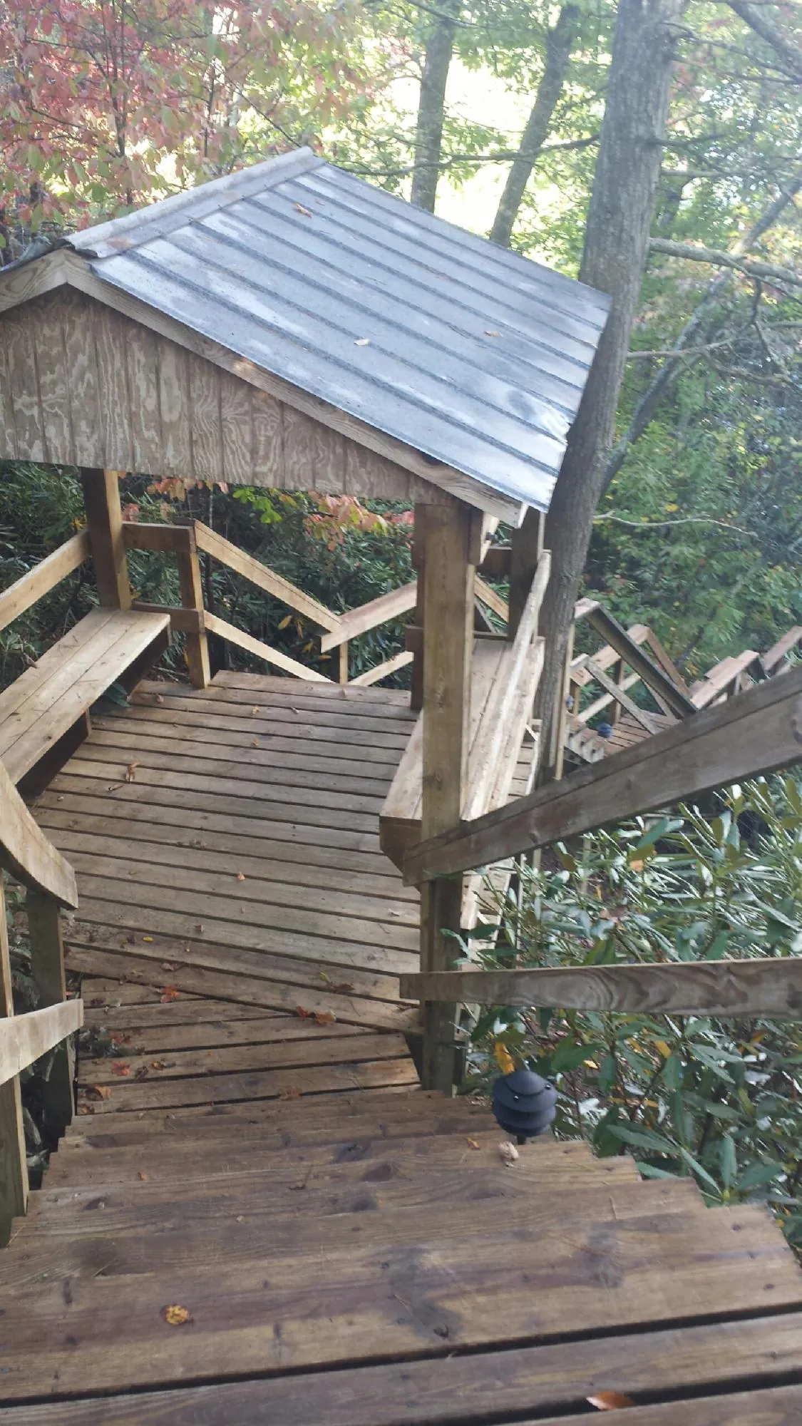 Metal roofed shelter over wooden steps on a wooded walkway — Skylight Repair & Installation work by our crew in Saukville