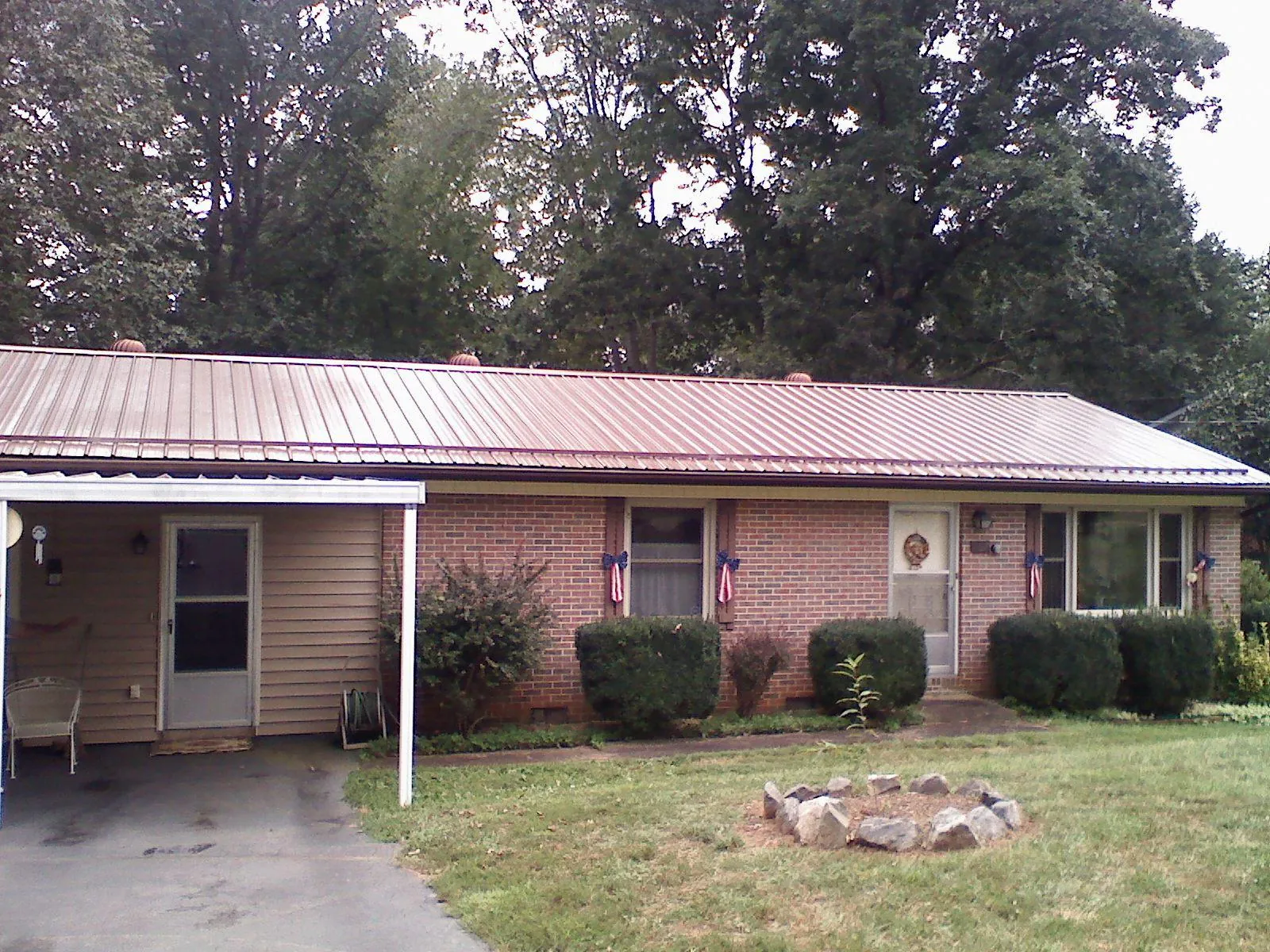 Bronze metal roof and carport on a brick ranch home — Roof Repair work by our crew in Saukville